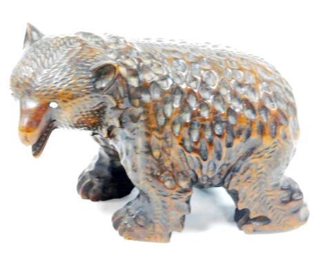 A Black Forest style carved model of a brown bear, in a slightly humorous standing pose, with glass bead eyes, 11cm high, 16c