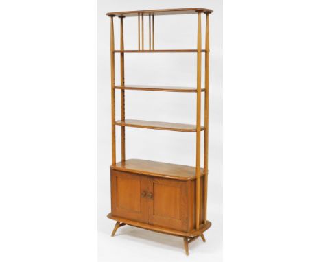 A mid century Ercol light elm cupboard whatnot, with an oval three shelf top, raised on a cupboard base over turned feet, 191