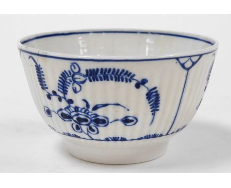 A late 18thC Caughley porcelain tea bowl, with vertical fluting, decorated in blue and white with floral sprays, crescent mar