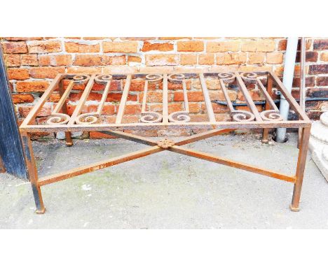 An unusual cast iron coffee table, with scroll carved top, plain supports and X shaped stretcher, possibly constructed from a