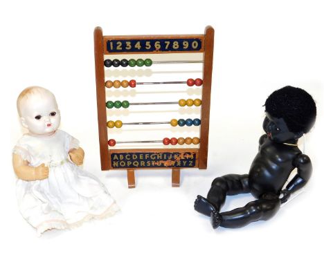 A vintage Chad Valley abacus, 39cm high, together with a Rosebud black composition doll, and a mid century celluloid doll. (3