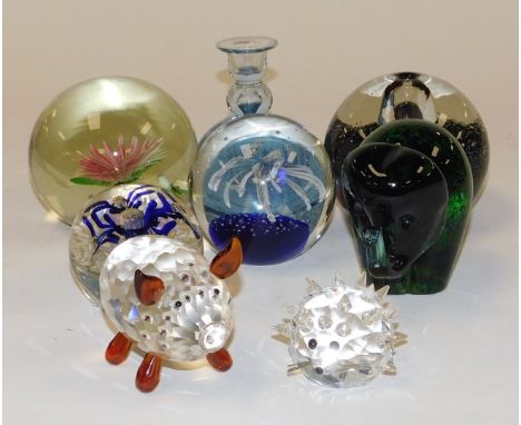 A group of glass paperweights, one inset with a pink and white flower, 10cm diameter, together with a Wedgwood paperweight mo