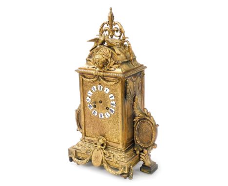 A late 19thC French gilt metal mantel clock, with black and white enamelled Roman numerals, the highly ornate case surmounted