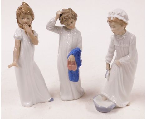 Three Nao porcelain figures, modelled as a young girl yawning, 31cm high, a young girl bathing feet, and a young boy holding 