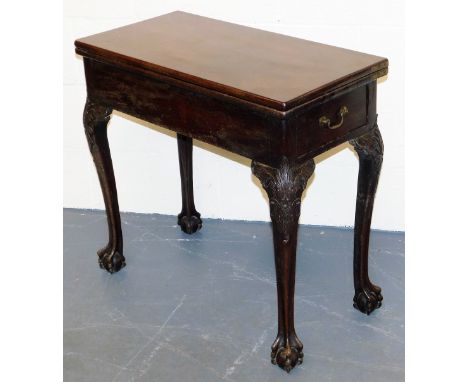 A George III mahogany fold over card table, the rectangular top enclosing a baize interior, on carved cabriole legs with ball