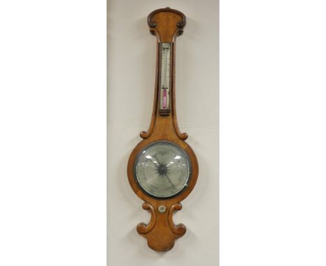 A Victorian oak cased wheel barometer, with a silvered dial and thermometer, 90cm high.
