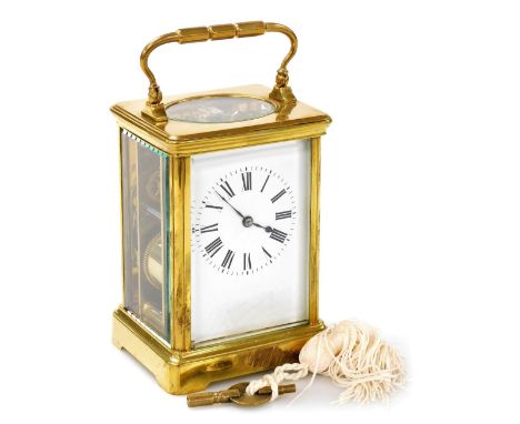 A brass cased carriage clock bearing Scouting crest, with white enamel dial and Roman numerals, the plain brass case with Sco
