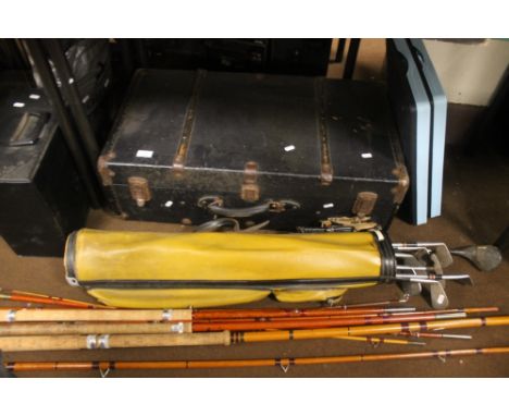 A WOOD BOUND TRUNK TOGETHER WITH THREE VINTAGE FISHING RODS and a collection of golf clubs