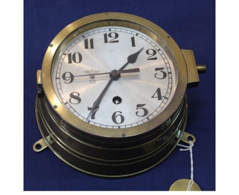 A Third Reich era Kriegsmarine bulkhead clock in brass case, the silvered dial marked with eagle over M., the lock and hinge 