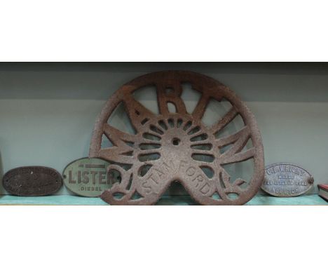 A cast iron Stamford tractor seat plus three metal signs, Lister, R Boby and O B Wright