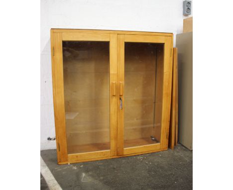 A light walnut finish cabinet enclosed by two glazed panel doors with three adjustable shelves.99cm(W) 106cm(H) 30cm(D)