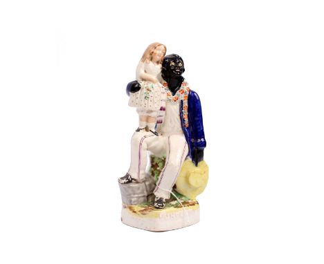 Victorian Staffordshire figure of Uncle Tom and Eva, decorated in under-glaze blue., black and yellow with over glaze enamel 