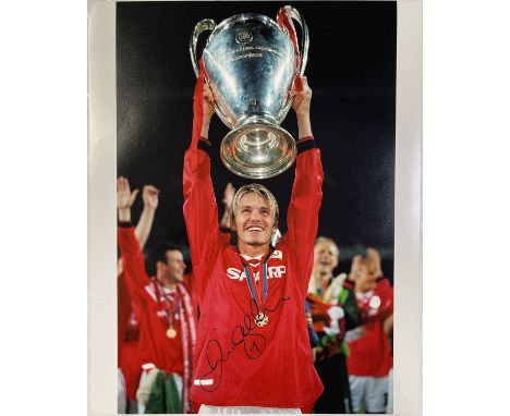 A high-quality photo print from the original negative of David Beckham holding the Champions League trophy aloft in 1999, sig