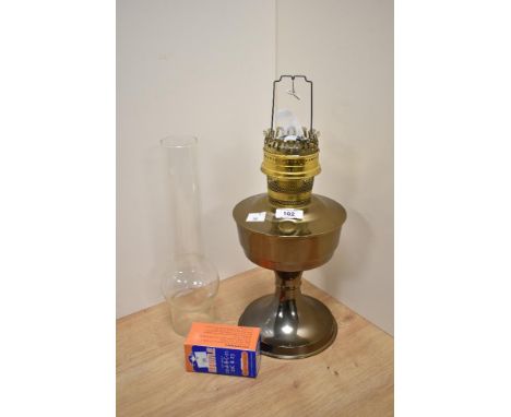 A vintage brass oil lamp base with glass chimney.