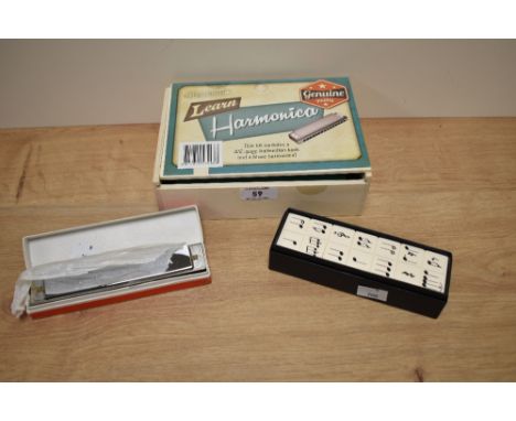 A boxed Hinkler harmonica, with book for learning, a Suzuki Winner harmonica, and a box of wooden musical dominoes