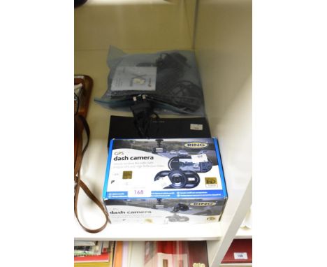 A boxed Ring GPS dash camera, a Goodman's alarm clock radio, and a TomTom