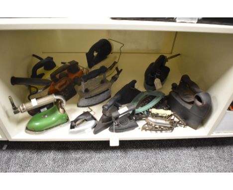A collection of fifteen vintage and antique irons and trivets, including flat irons, gas and early electric examples.