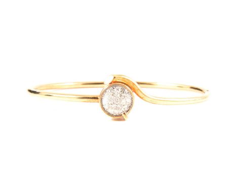 A diamond set half-hinged bangle, the thirteen small round brilliant cut diamonds illusion set in a circular design, in yello
