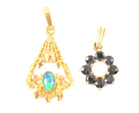 A modernist opal pendant, the oval cabochon cut opal bezel set in a textured abstract triangular design, mount tests as gold,