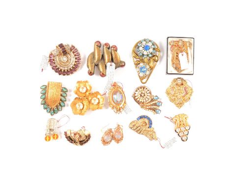 Fourteen gilt metal clips and brooches circa 1930-1950, a 50mm brooch set with a fan of amethyst and clear paste and scroll t