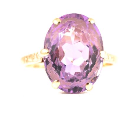 A 9 carat gold amethyst dress ring, the oval mixed cut stone, 16x12mm claw set in a 9 carat yellow gold mount ring size R, Bi