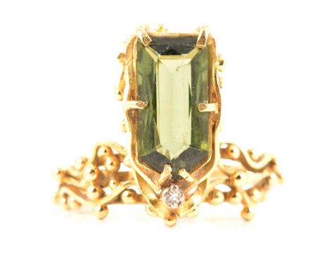 A handmade design 18 carat gold ring set with green tourmaline, the rectangular arrow shaped tourmaline, 12.7 x 7.5mm, held b