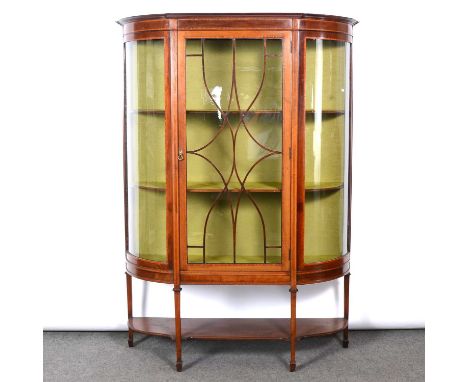 Late Victorian inlaid mahogany display cabinet, bowfront, the glazed door and panels enclosing two shelves, square tapering l