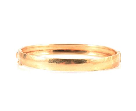 A 9 carat yellow gold half hinged bangle, 6mm wide plain polished hollow construction, 10.8g.