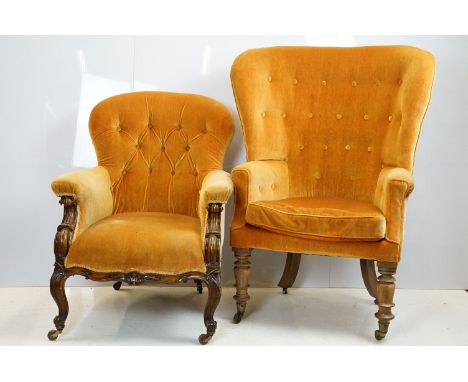 Early 20th century wing back armchair of curved form, with button back, upholstered in orange, on turned legs and castors, 11