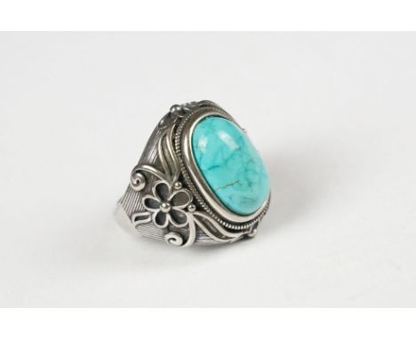 A 925 sterling silver ring set with turquoise cabochon, decorative shoulders, marked 925 for sterling silver to the inner sha