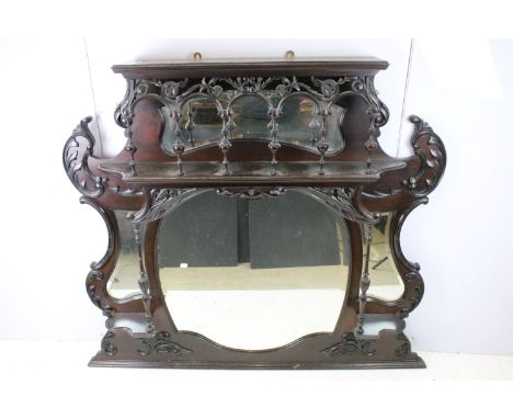 Art Nouveau mahogany overmantel mirror, carved with scrolling flowers and foliage, with two candle shelves, 121cm high x 127c