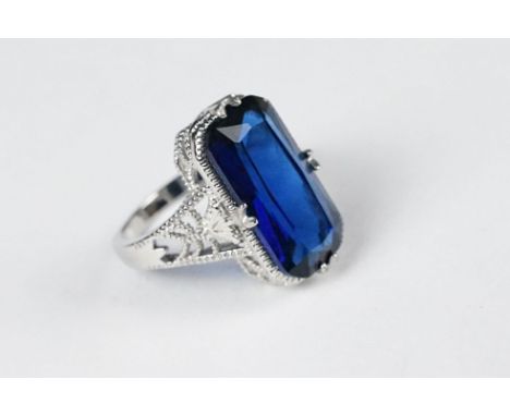 A 925 sterling silver ladies dress ring set with large blue stone, filigree shoulders, marked 925 for sterling silver to the 