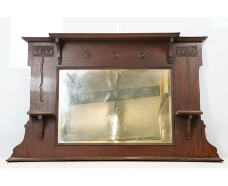 Early 20th century mahogany overmantel mirror, with Art Nouveau style carved stylised flowers and candle shelves, 84cm high x