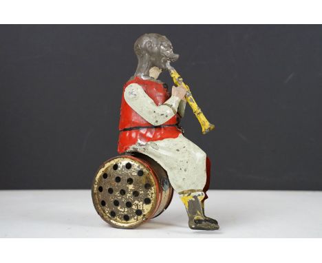 Early 20th century German tinplate clockwork toy, in the manner of Gunthermann, modelled as a clown playing a clarinet, seate