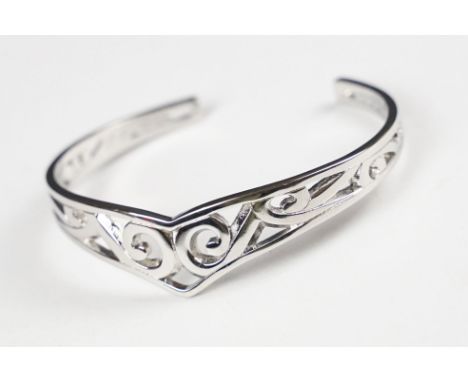 A 925 sterling silver open ended bangle with pierced Celtic style decoration, marked 925 for sterling silver to the verso. 