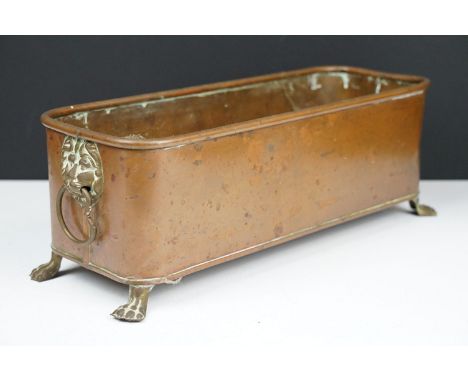 Copper planter of rectangular form with rounded corners and rolled edge, having a pair of lion mask drop ring handles and rai