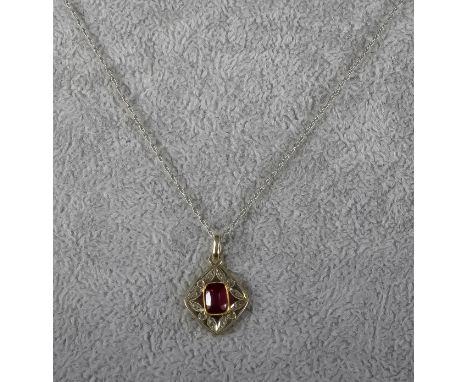 A Ruby and Diamond Pendant, Modern, in 14ct white gold mount, set with centre ruby approximately .75ct, surrounded by small d