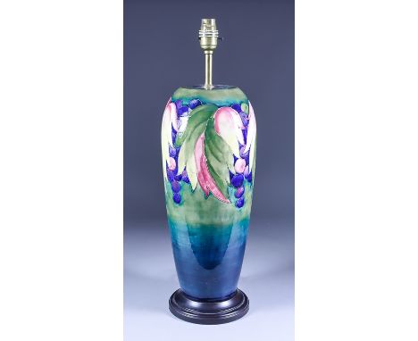 A Moorcroft Pottery Table Lamp with "Grape and Leaf" design, on turned wooden base, 20.5ins high overall