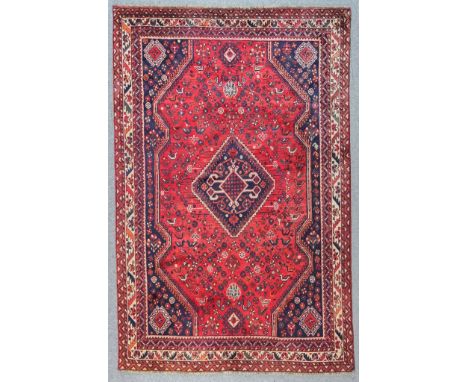 A Modern Indian Carpet of "Kazak" Design, woven in colours of navy blue, wine and ivory, with a central serrated lozenge shap
