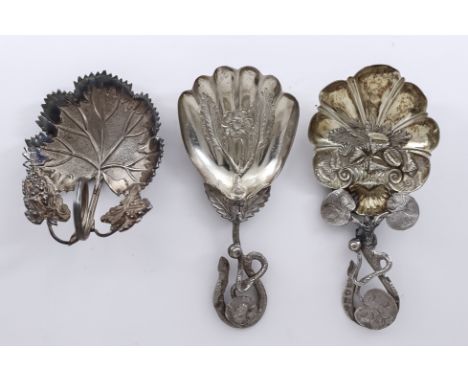 A Victorian Silver and Silver Gilt Caddy Spoon and Two Other Caddy Sppons, one embossed with various shells and with lilypad 