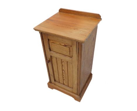 A late 19th/early 20th century Oregon pine bedside cupboard: galleried top above single door with fielded panel, raised on br