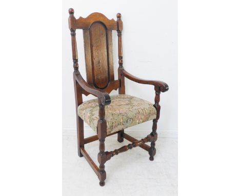 A good reproduction open armchair of large proportions: arched top and oval fielded panel above a tapestry depicting medieval
