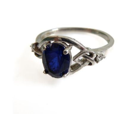 A silver dress ring set with an oval vertically aligned dark-blue stone within an openwork Celtic design shank (boxed)