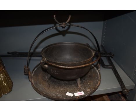A vintage cast iron handled pot and stand including bracket to hold over fire.
