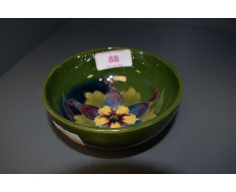 A vintage Moorcroft footed finger bowl with typical hibiscus decoration on green ground, paper label to base, approx. height 