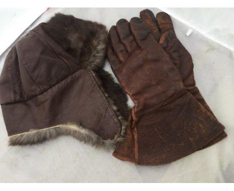 A pair of brown leather gauntlets and a fur lined brown leather helmet. 