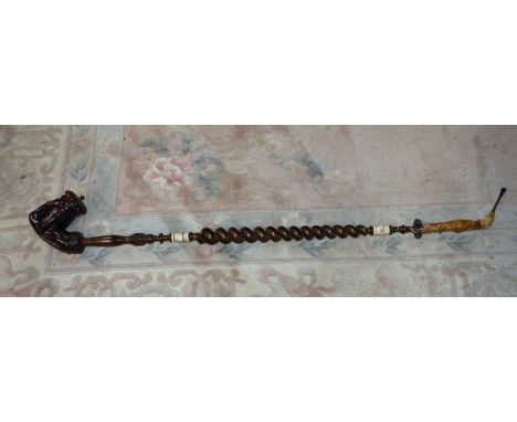 A large 19th century Black Forrest pipe, the rope twist stem with ivory mounts, the covered bowl in claw setting, 50" (tube t