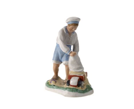  A Biscuit Porcelain Figurine of a Boy Playing with a Car  DMITROVSKIY MANUFACTORY, MOSCOW, 1930–1931 Height 12 cm.Realistica