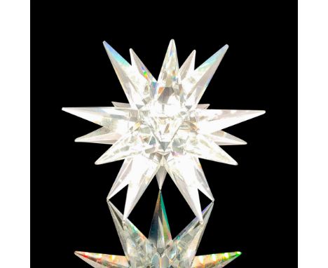 A clear crystal figure of a star with multiple points emerging from the center with a space for candlesticks. Swarovski backs