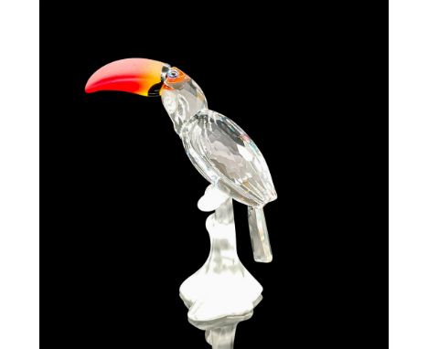 Sparkling faceted and molded crystal figurine modeled as a toucan perched on a branch. Colorful beak and eye details. Swarovs